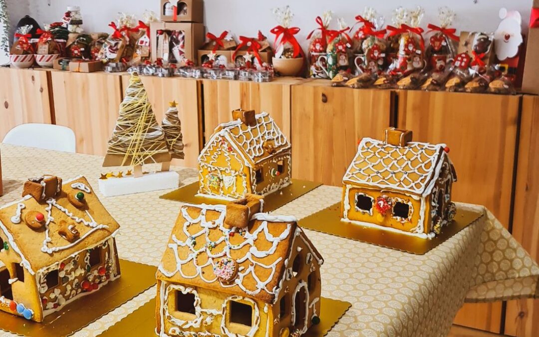 Casas de bolacha decoradas pelos miúdos, em cartões dourados, na mesa do Espaço QB