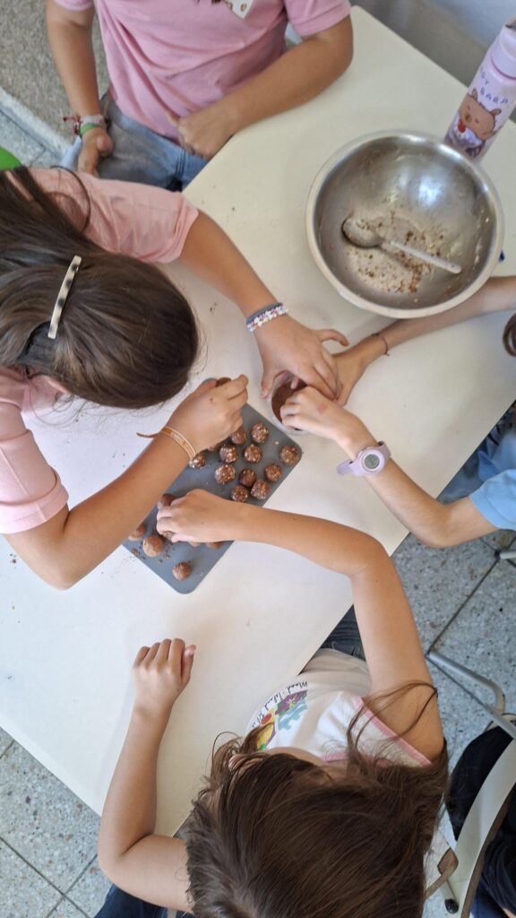 Crianças a passar as bolinhas energéticas no cacau