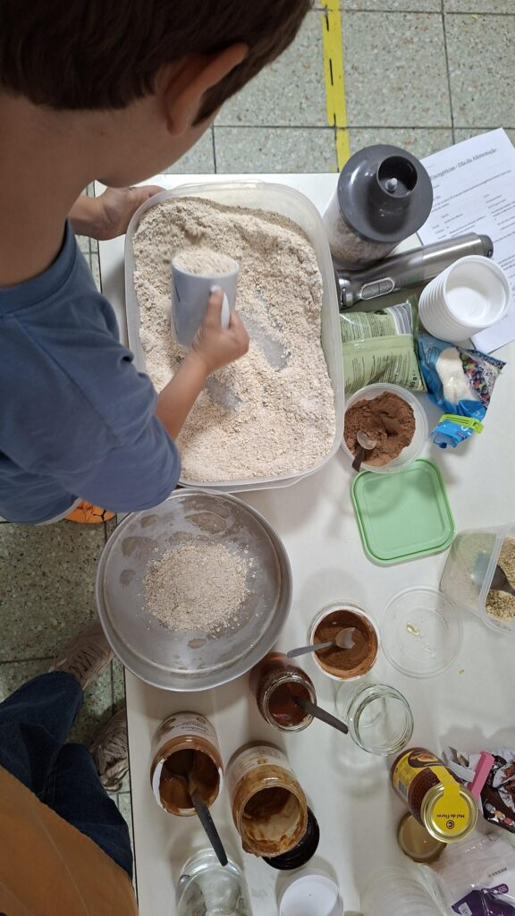 Criança a medir flocos de aveia moídos com uma chávena