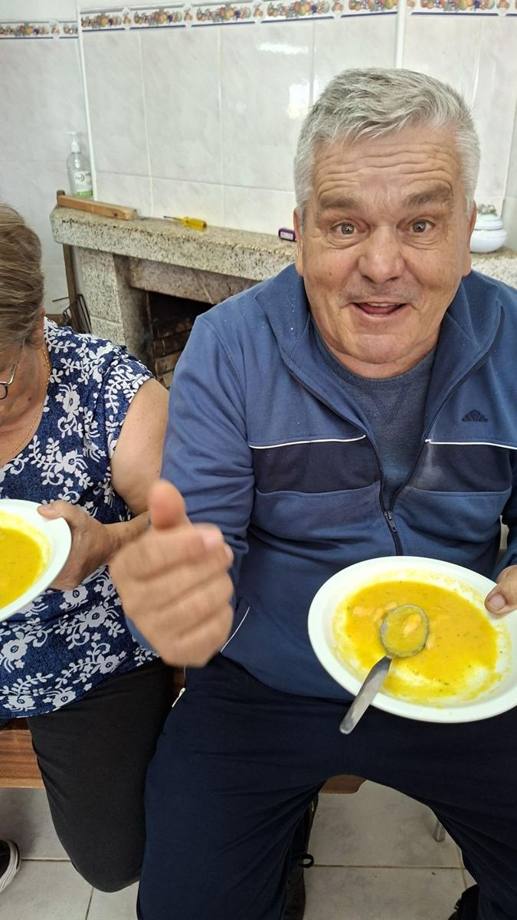 Participante a fazer sinal de aprovação com o prato de sopa