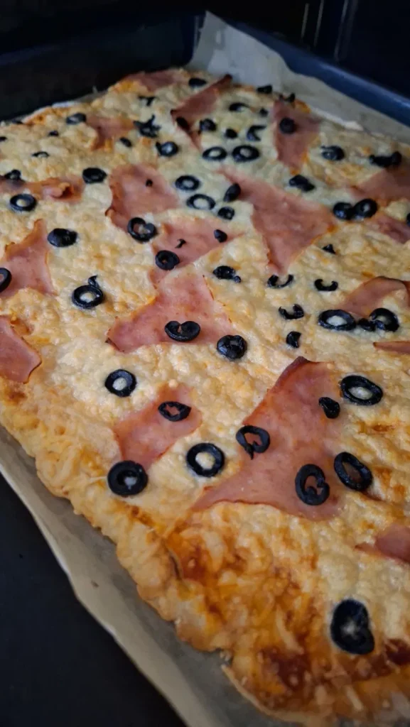 Pizza com massa de iogurte, queijo gratinado, fiambre e azeitonas pretas