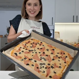 Andreia Gomes com um tabuleiro de pizza com massa de iogurte, fiambre e azeitonas