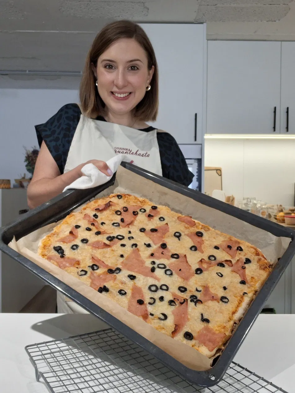 Andreia Gomes com um tabuleiro de pizza com massa de iogurte, fiambre e azeitonas
