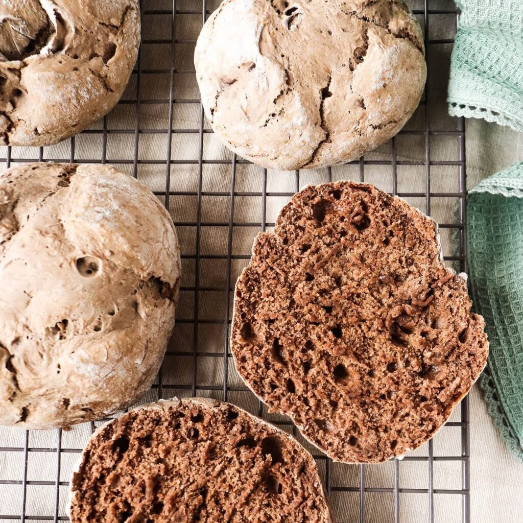 Pães de alfarroba e centeio com miolo escuro, numa grelha
