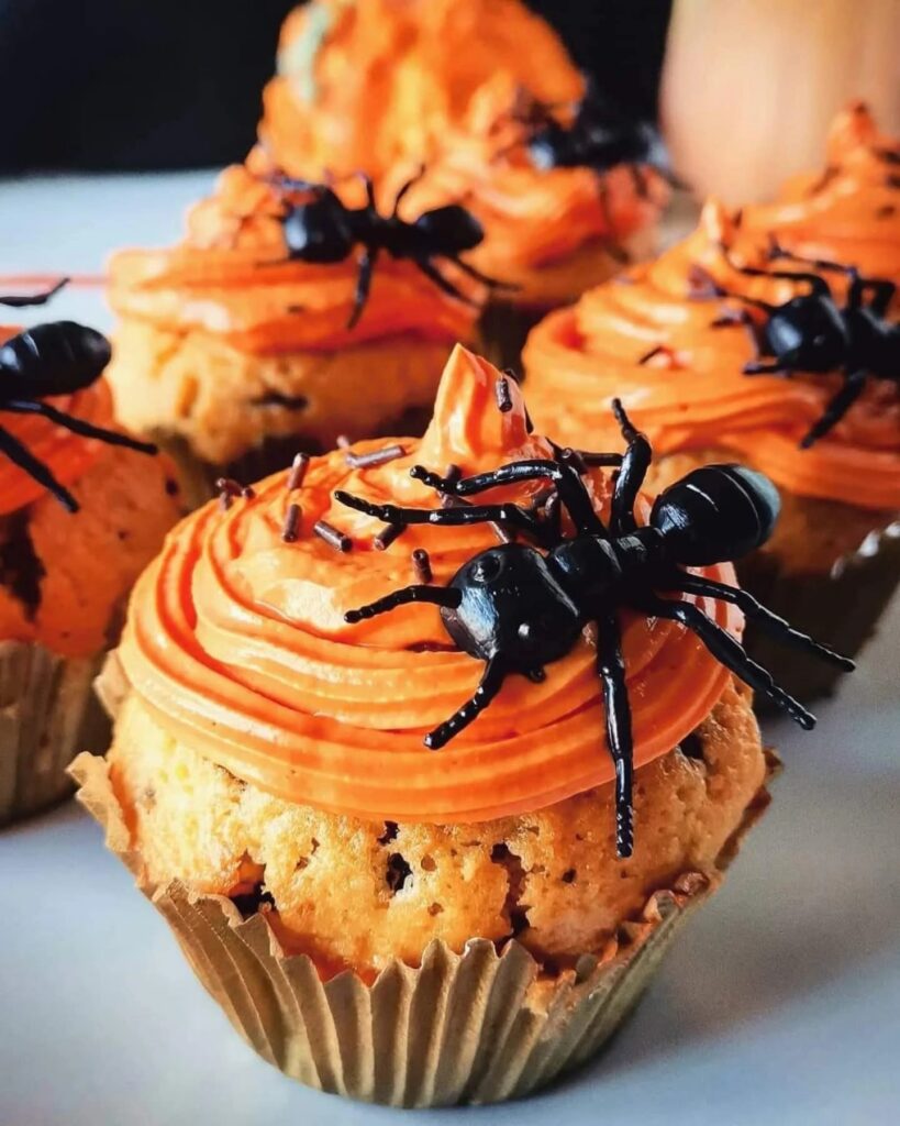 Cupcakes de formiga para o Halloween com cobertura laranja e aranhas