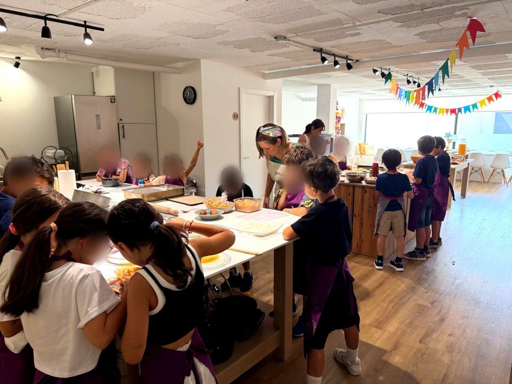 Crianças a cozinhar em equipas numa festa de aniversário no Espaço QB